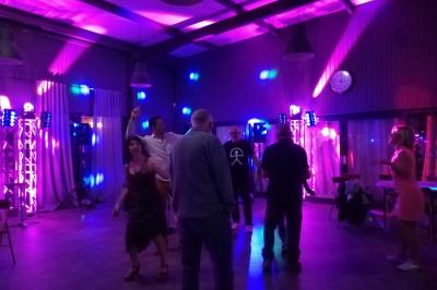 Jeu de lumières colorées projetées depuis une installation de DJ avec une table et des structures lumineuses.