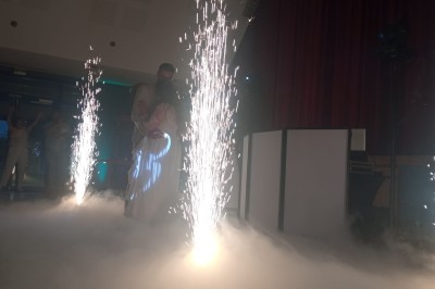 Deux hommes dansent ensemble sur une piste éclairée par des lumières colorées dans une ambiance festive.
