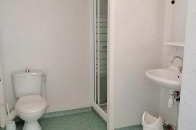 Village rural avec église au centre, maisons environnantes, arbres dénudés et paysage vallonné en arrière-plan.