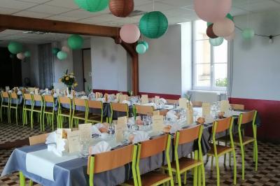 Village rural avec église au centre, maisons environnantes, arbres dénudés et paysage vallonné en arrière-plan.