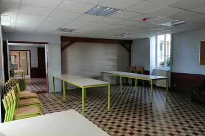 Village rural avec église au centre, maisons environnantes, arbres dénudés et paysage vallonné en arrière-plan.