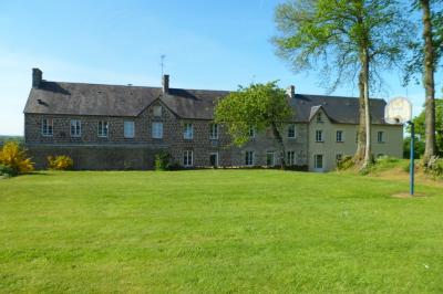 Village rural avec église au centre, maisons environnantes, arbres dénudés et paysage vallonné en arrière-plan.