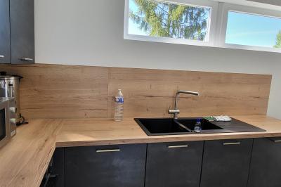 Parking extérieur avec marquages au sol, quelques voitures stationnées, bâtiments et champs en arrière-plan.