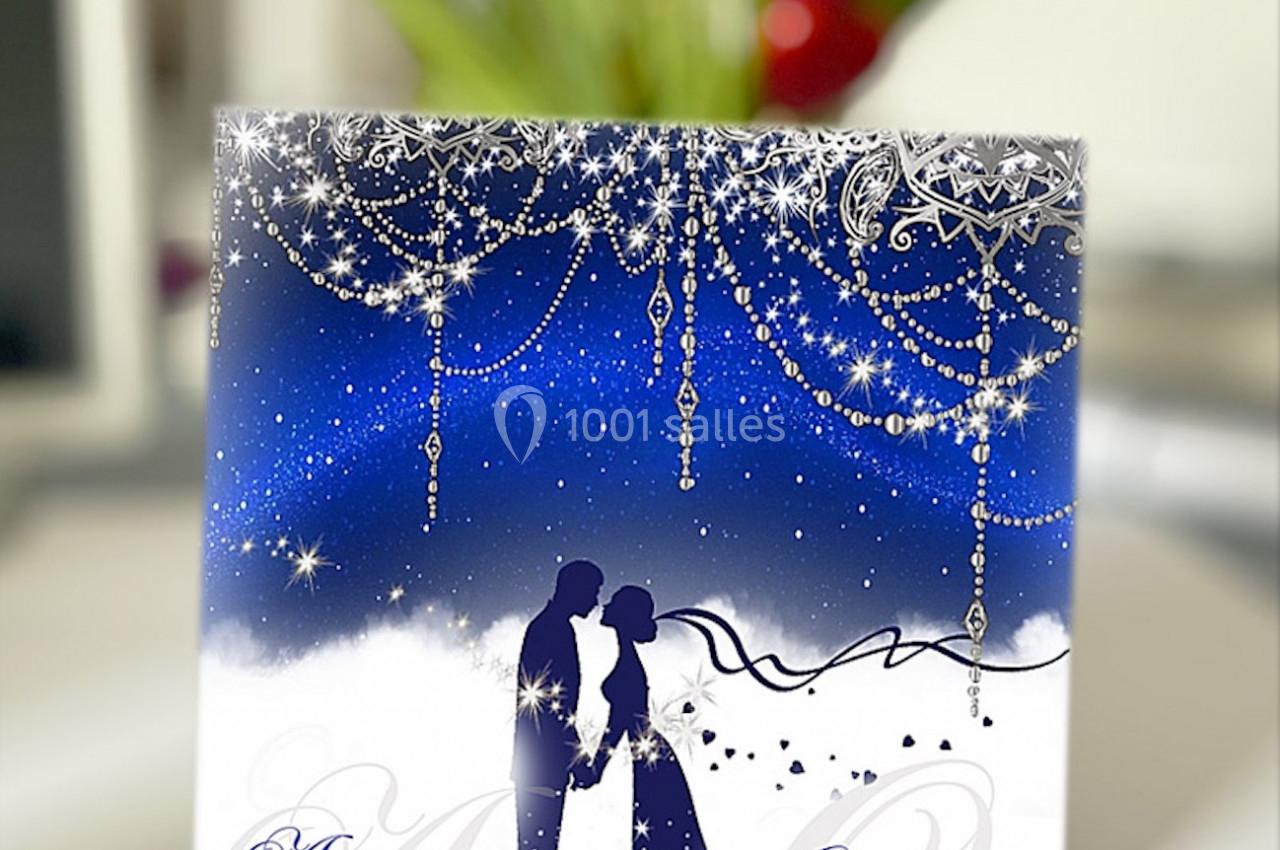 Un couple silhouetté se tenant la main sous un ciel étoilé décoré de guirlandes scintillantes.