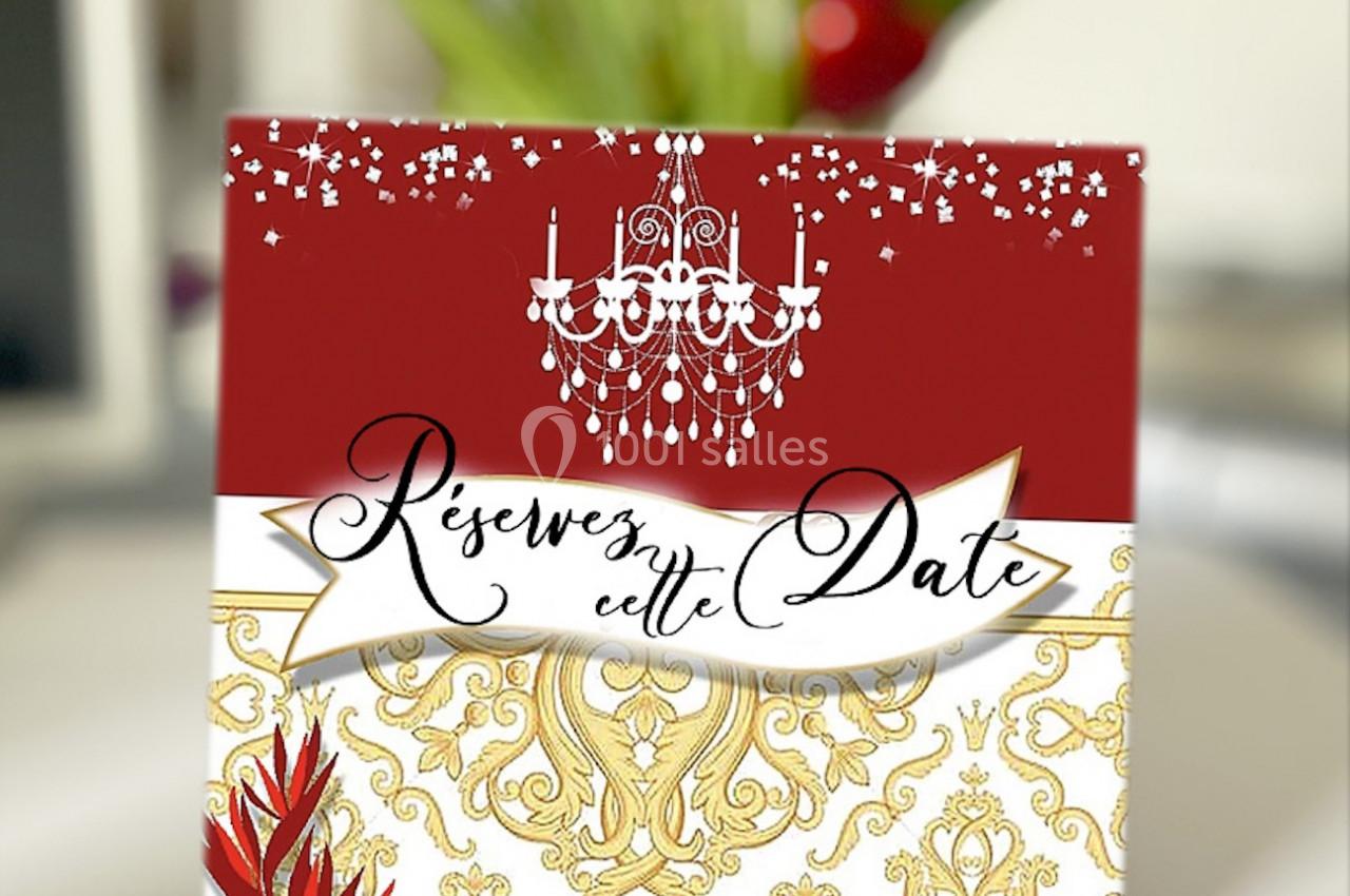 Carte élégante avec un design rouge et doré, un lustre, des alliances et l'inscription ’Réservez cette date’.