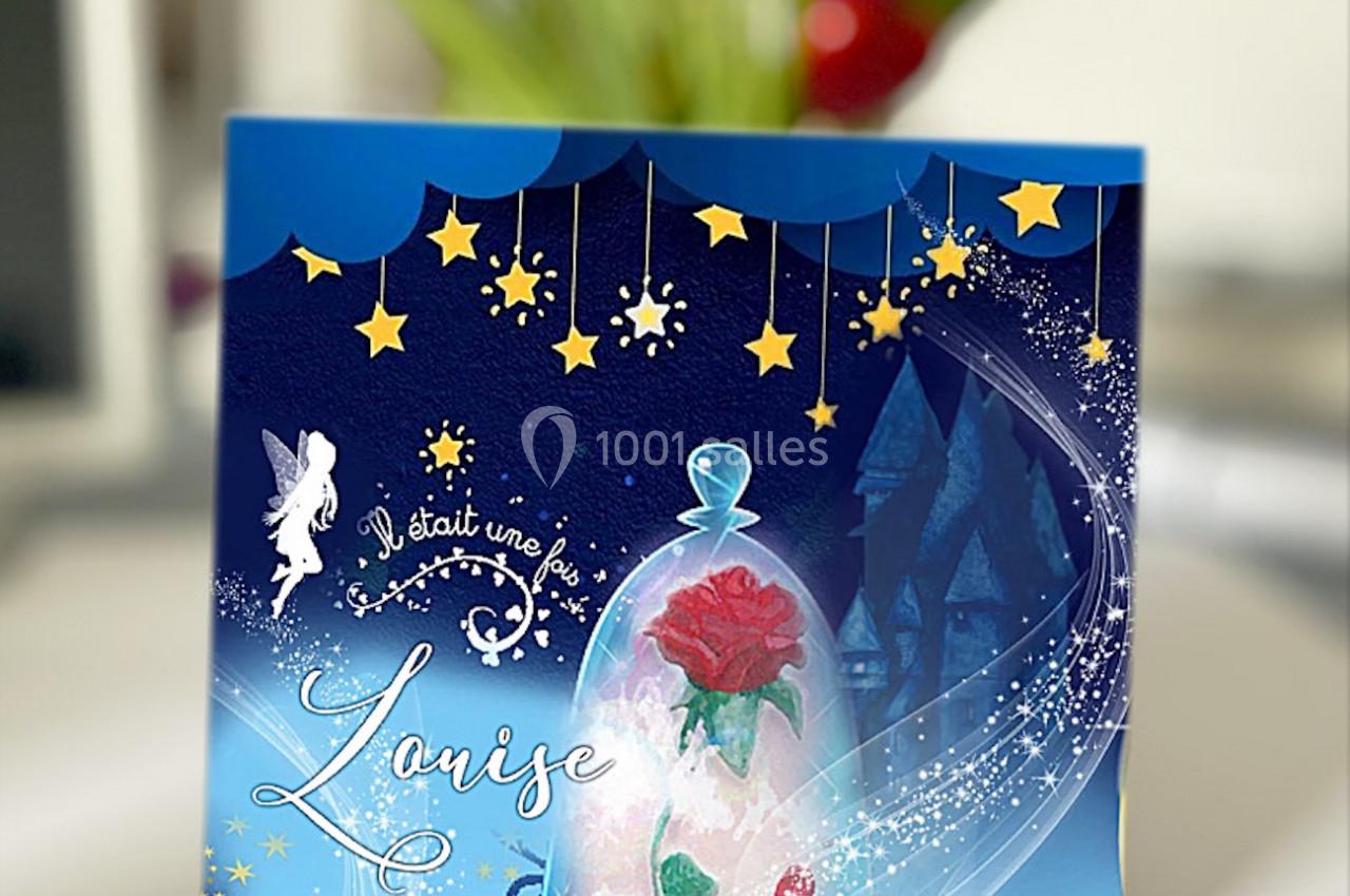 Carte décorative sur le thème de la Belle et la Bête, avec une rose sous cloche et des étoiles dorées en arrière-plan.