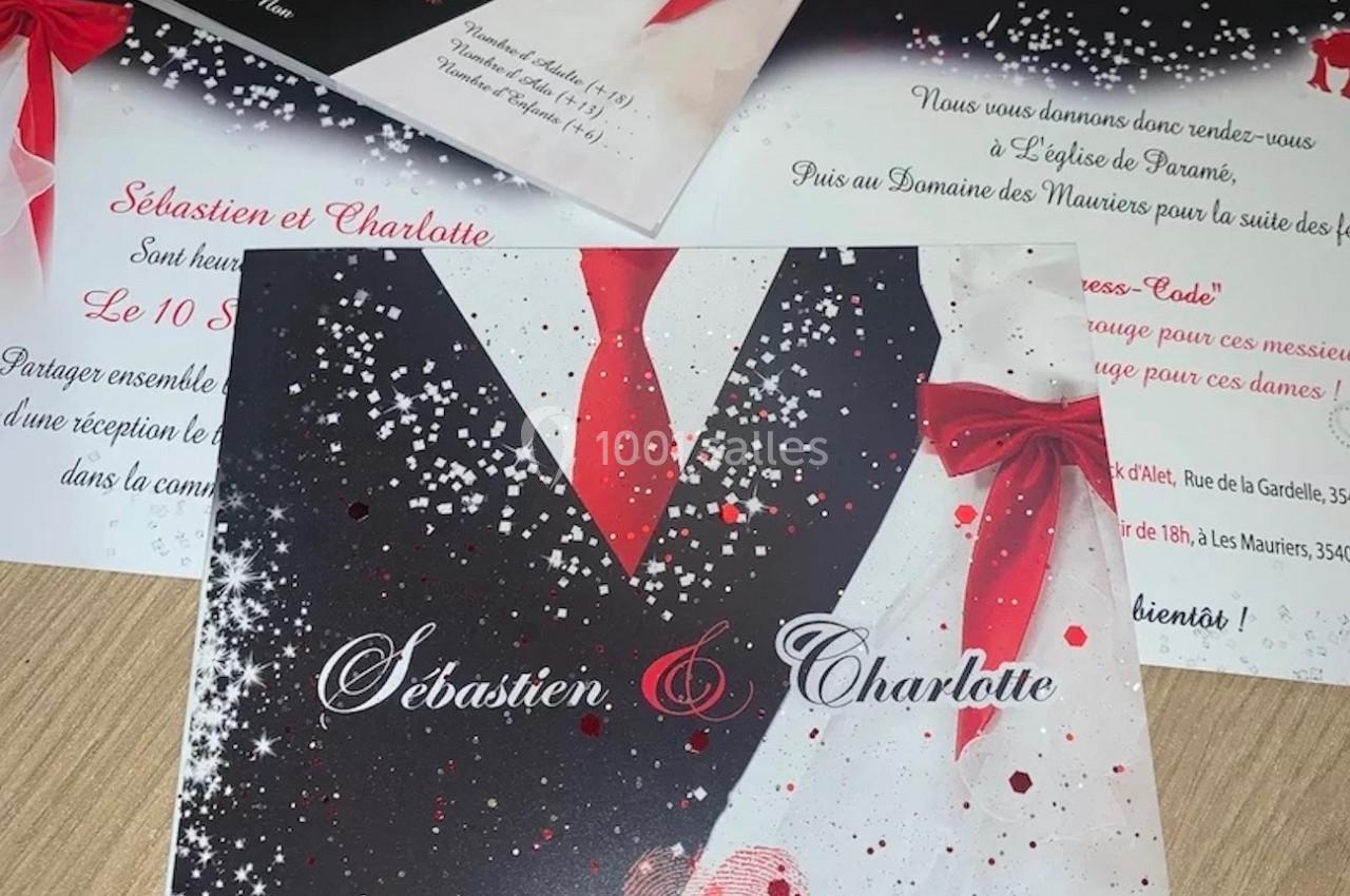 Cartes d'invitation de mariage avec un design de costume noir, cravate rouge et détails festifs.