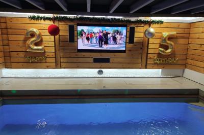 Salle vide avec parquet, murs en bois, décorations dorées et une boule disco suspendue au plafond.