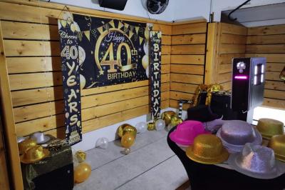 Salle vide avec parquet, murs en bois, décorations dorées et une boule disco suspendue au plafond.