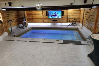 Salle vide avec parquet, murs en bois, décorations dorées et une boule disco suspendue au plafond.