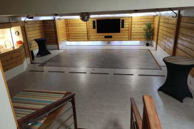 Salle vide avec parquet, murs en bois, décorations dorées et une boule disco suspendue au plafond.