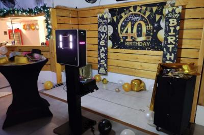 Salle vide avec parquet, murs en bois, décorations dorées et une boule disco suspendue au plafond.