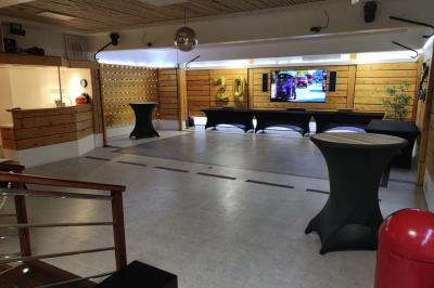 Salle vide avec parquet, murs en bois, décorations dorées et une boule disco suspendue au plafond.