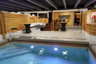 Salle vide avec parquet, murs en bois, décorations dorées et une boule disco suspendue au plafond.