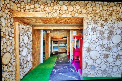 Salle vide avec parquet, murs en bois, décorations dorées et une boule disco suspendue au plafond.