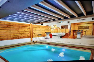 Salle vide avec parquet, murs en bois, décorations dorées et une boule disco suspendue au plafond.