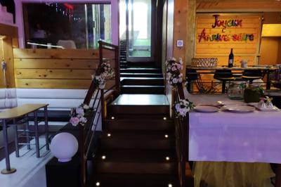 Salle vide avec parquet, murs en bois, décorations dorées et une boule disco suspendue au plafond.