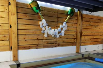 Salle vide avec parquet, murs en bois, décorations dorées et une boule disco suspendue au plafond.