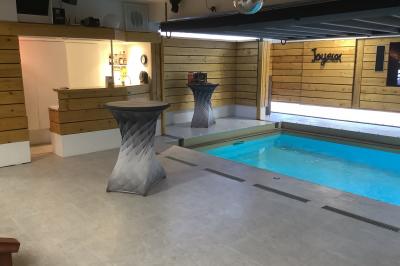 Salle vide avec parquet, murs en bois, décorations dorées et une boule disco suspendue au plafond.