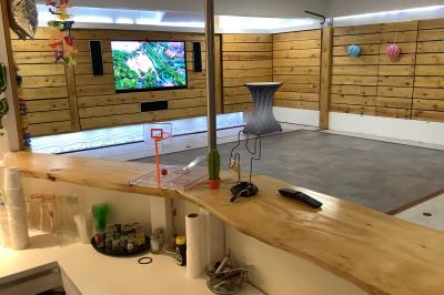 Salle vide avec parquet, murs en bois, décorations dorées et une boule disco suspendue au plafond.