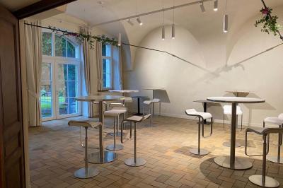 Deux colonnes en pierre encadrent un espace avec deux bureaux modernes, éclairés par des lampes murales.