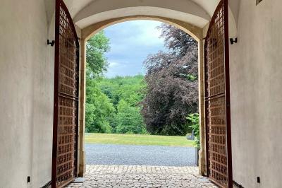 Deux colonnes en pierre encadrent un espace avec deux bureaux modernes, éclairés par des lampes murales.