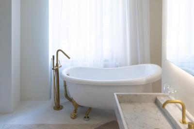 Deux colonnes en pierre encadrent un espace avec deux bureaux modernes, éclairés par des lampes murales.