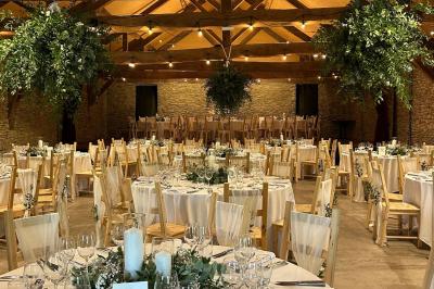 Deux colonnes en pierre encadrent un espace avec deux bureaux modernes, éclairés par des lampes murales.