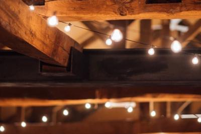 Deux colonnes en pierre encadrent un espace avec deux bureaux modernes, éclairés par des lampes murales.