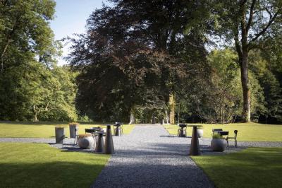 Deux colonnes en pierre encadrent un espace avec deux bureaux modernes, éclairés par des lampes murales.