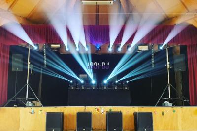 Un couple danse dans une salle éclairée par des lumières colorées et entourée de fumée.