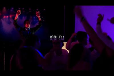 Salle de réception en pierre avec invités assis et debout, décorations florales suspendues et ambiance chaleureuse.