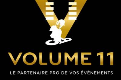 Salle de réception en pierre avec invités assis et debout, décorations florales suspendues et ambiance chaleureuse.