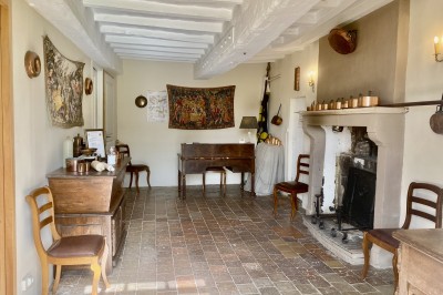 Château éclairé de nuit avec des lumières colorées, entouré de buissons et de tentes blanches sous un ciel nuageux.