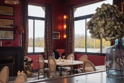 Maquette de voilier avec une grande voile blanche exposée devant un mur bleu orné de cadres et d'une applique murale.