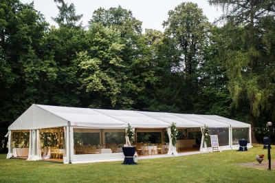 Maquette de voilier avec une grande voile blanche exposée devant un mur bleu orné de cadres et d'une applique murale.