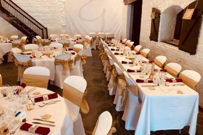 Terrasse en bois avec salon de jardin, sauna en forme de tonneau, jacuzzi et clôture en bois, entourée de verdure.