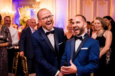 Main avec un tatouage de triangles entrelacés, posée sur des cheveux bruns, bracelet en perles noires visible.