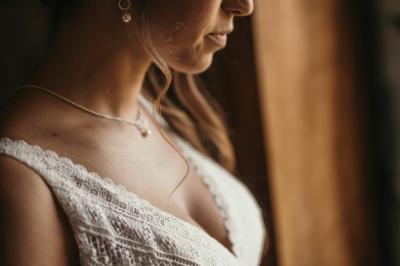 Un couple assis lors d'une cérémonie, l'homme ému essuie une larme tandis que la femme le regarde avec tendresse.