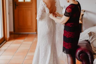 Un couple assis lors d'une cérémonie, l'homme ému essuie une larme tandis que la femme le regarde avec tendresse.