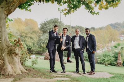 Un couple assis lors d'une cérémonie, l'homme ému essuie une larme tandis que la femme le regarde avec tendresse.