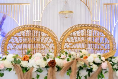 Salle de réception décorée avec des tables rondes, des chaises blanches, des chandeliers et des drapés blancs au plafond.