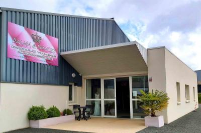 Robes élégantes sur mannequins et vêtements suspendus dans une pièce lumineuse avec rangements et cintres.