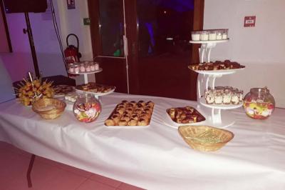 Un couple coupe un gâteau éclairé de bougies étincelantes lors d'une fête dans une salle décorée.
