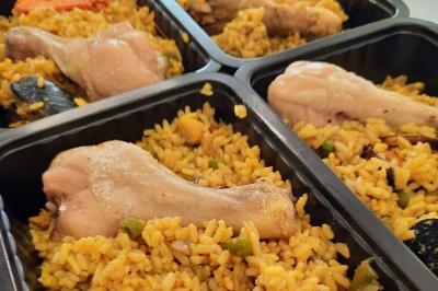 Un couple coupe un gâteau éclairé de bougies étincelantes lors d'une fête dans une salle décorée.