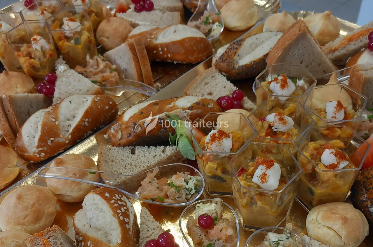 Plateau de buffet avec assortiments de pains, verrines, cuillères apéritives et garnitures colorées.
