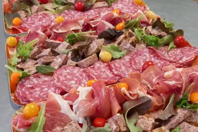 Un couple coupe un gâteau éclairé de bougies étincelantes lors d'une fête dans une salle décorée.