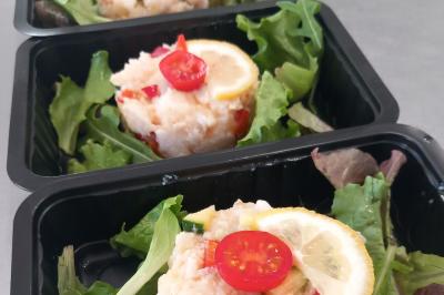 Un couple coupe un gâteau éclairé de bougies étincelantes lors d'une fête dans une salle décorée.