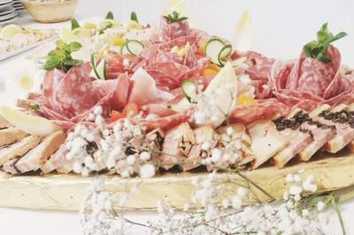 Un couple coupe un gâteau éclairé de bougies étincelantes lors d'une fête dans une salle décorée.