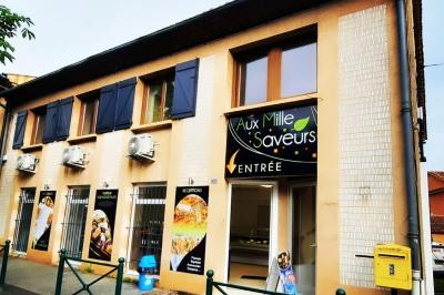 Un couple coupe un gâteau éclairé de bougies étincelantes lors d'une fête dans une salle décorée.